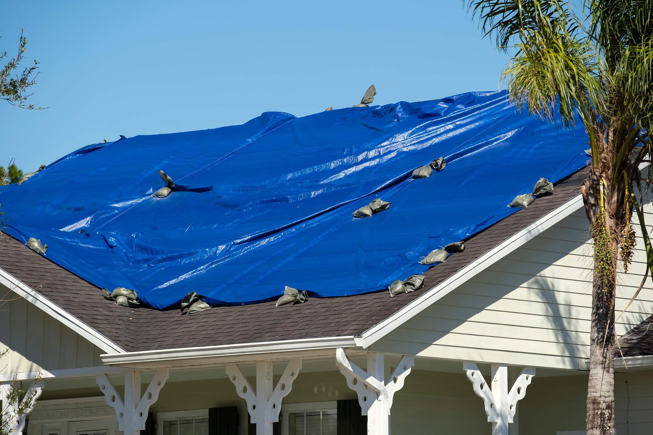 Roof with blue tarp covering due to leak